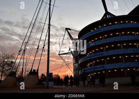 Fans arrive at the Etihad Stadium as the sun sets before the game Stock Photo