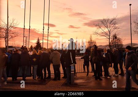 Fans arrive to catch a glimpse of the team bus at the Etihad Stadium as the sun sets before the game Stock Photo