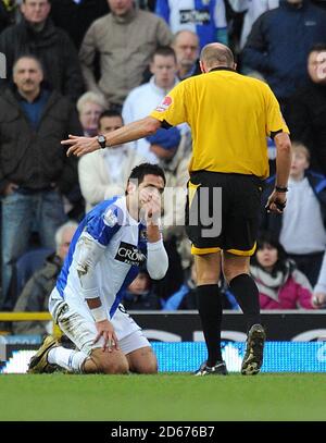 Referee Steve Bennett points to Blackburn Rovers' Roque Santa Cruz to tell him to get up Stock Photo