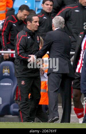 Sunderland manager Ricky Sbragia (left) shakes hands with Manchester City manager Mark Hughes after the match Stock Photo