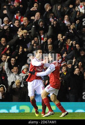 Arsenal's Samir Nasri (right) celebrates scoring his side's second goal of the game with teammate Robin van Persie (left) in front of the away fans  Stock Photo