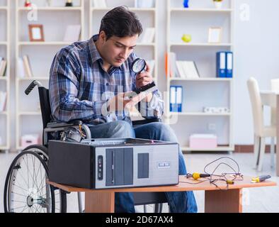 The computer repairman on wheelchair working Stock Photo