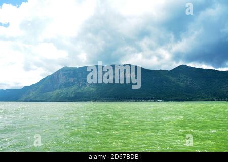 deep green mountain and green water lake under dark clouds before storm coming Stock Photo