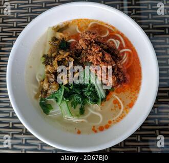 minced meat and green vegetables on the noodles in the red oil soup Stock Photo