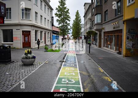 Laugavegur, the main shopping street in Reykjavik, Iceland. Colourful boxes containing numbers counting upwards from 53 are painted on to the road. Stock Photo