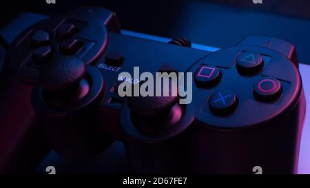 Game controller under blue and red lights in a dark room Stock Photo