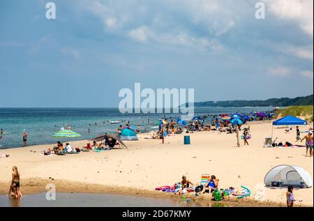 Sunbathers, swimmers and beachcombers enjoy a hot summer day at a sandy Lake Michigan beach in Warren Dunes State Park near Sawyer, Mich., USA. Stock Photo