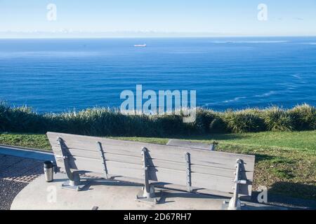 Empty bench seat with a view of the Tasman Sea from Lawrence Hargraves Lookout, Bald Hill, Stanwell Tops. Stock Photo