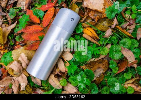A can of deodorant or air freshener thrown out on the lawn in the autumn grass