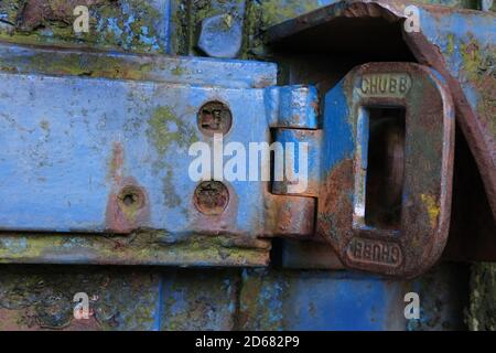 Rusting heavy weight hasp on blue painted security door. Stock Photo