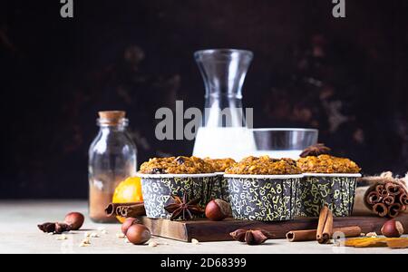 Sweet pumpkin vegan muffins with fall spices on wooden board. Autumn dessert. Healthy baking concept. Stock Photo