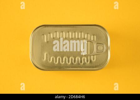 Top of a sardine can with ring pull on a yellow background Stock Photo