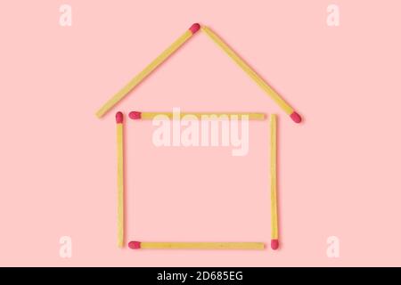 House made from matches on pink background - Concept of woman and house Stock Photo
