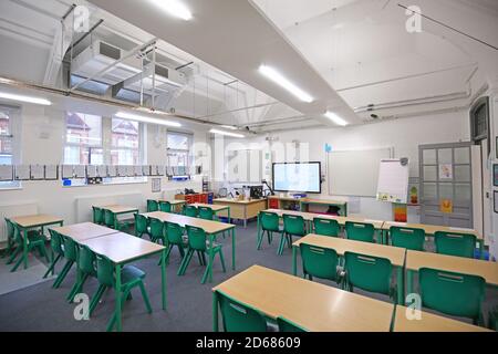 Newly refurbished Victorian school classroom with desks arranged facing the front. Traditional layout reintroduced during the Covid pandemic of 2020. Stock Photo