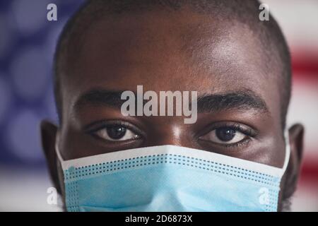 Close-up of African young man wearing protective mask during pandemic he looking at camera Stock Photo
