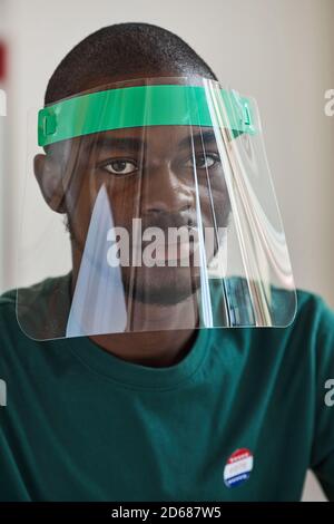 Close-up of African young man wearing protective mask looking at camera Stock Photo