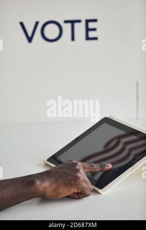Close-up of man using digital tablet to vote against the white background Stock Photo