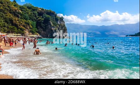 People swimming and taking sunbath on the Mogren beach. Budva, Montenegro. Stock Photo