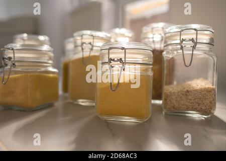 Collection of grain productsin storage jars over on kitchen. Jar of cereals in kitchen cupboard Stock Photo