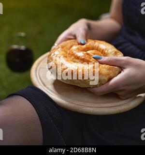 pies with vegetables in the hands of a woman on a tray. Cozy authentic atmosphere. Stock Photo