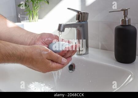Man use soap and washing hands under the water tap .Hygiene concept. Washing hands with soap