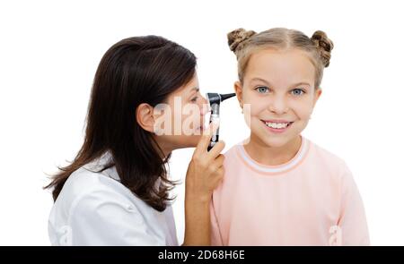 ENT doctor doing an ear exam with an otoscope to a pretty little girl, isolated on white background. Hearing clinic Stock Photo