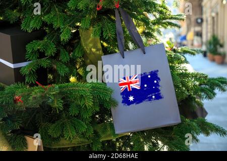 Australia flag printed on a Christmas shopping bag as a decoration on a Xmas tree on a street. Christmas shopping, local market sale Stock Photo
