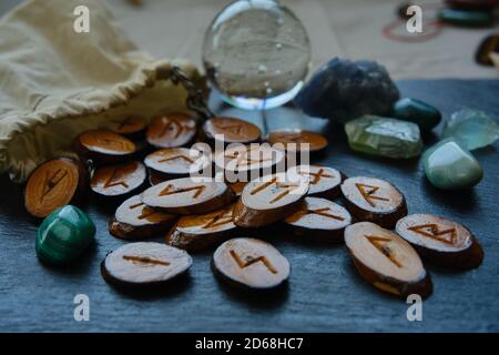 handmade wooden runes scattered on a black stone background Stock Photo ...