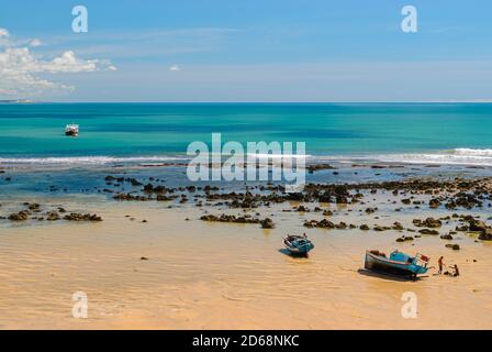 Pipa beach, Tibau do Sul, near Natal, Rio Grande do Norte, Brazil on May 7, 2008. Fisherman's boats anchored in the emerald sea on a sunny day. Stock Photo