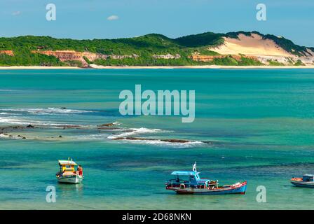 Pipa beach, Tibau do Sul, near Natal, Rio Grande do Norte, Brazil on May 7, 2008. Fisherman's boats anchored in the emerald sea on a sunny day. Stock Photo