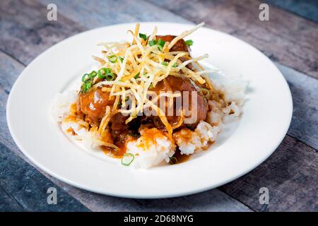 Fresh beef meatballs served with a sauce over a bed of rice Stock Photo