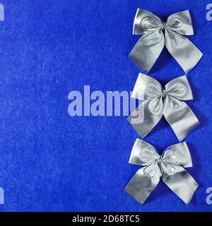 Colorful gift wrapping bows and silver sequins on white festive background.  Holiday copy space. Pull bow & ribbon, Top view Stock Photo - Alamy