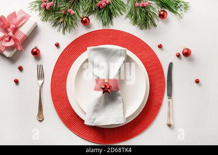 Christmas festive table setting with white and red holiday decorations, gift on white table. Top view. Stock Photo