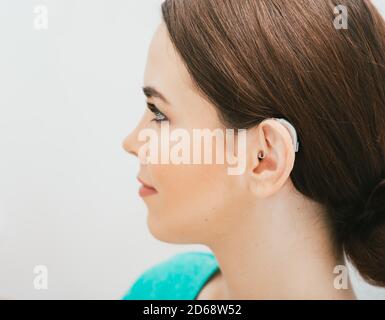 BTE hearing aid on female ear. Deafness treatment, hearing solution Stock Photo
