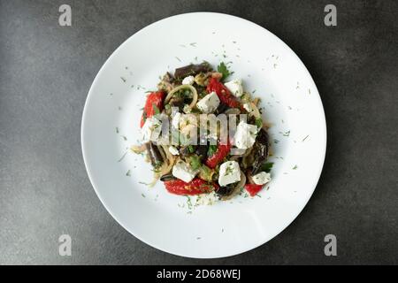 Salad with pickled eggplant, bell pepper and feta cheese. A delicious snack made from seasonal vegetables. Stock Photo