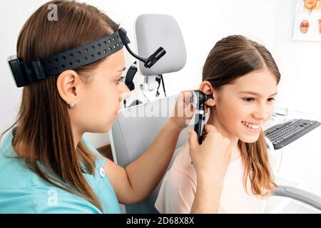 Audiologist doctor doing an ear exam with an otoscope to a child patient . Audiology. Hearing test Stock Photo