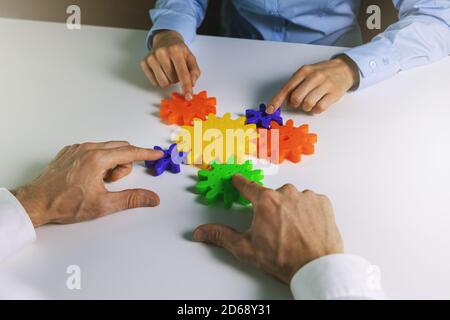 business cooperation, strategy and teamwork concept. business people team joining gears Stock Photo