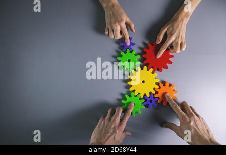 business development, teamwork and collaboration concept - people connecting gears. top view copy space Stock Photo