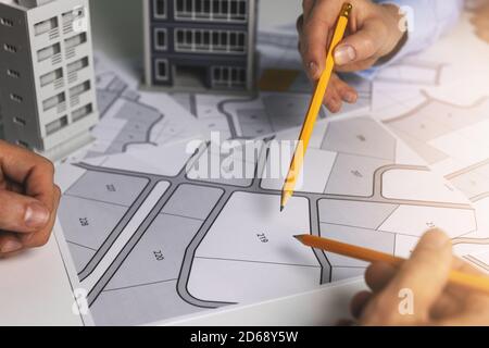 urban planning - people discussing about territory building plots on cadastral map for apartment building construction Stock Photo