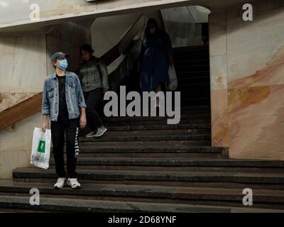 Moscow. Russia. October 5, 2020 People passengers with protective masks on their faces inside the metro station descend the stairs. Preventive Stock Photo