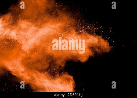 Orange powder explosion on black background. Stock Photo