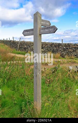 Wooden signpost with directions to Curbar Edge, Baslow Edge and White Edge near Calver, Derbyshire, Peak District National Park, England, UK.