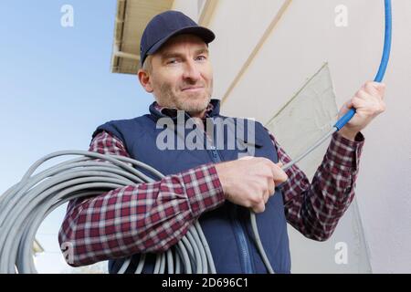 portrait of confident technician with cable coil outside Stock Photo