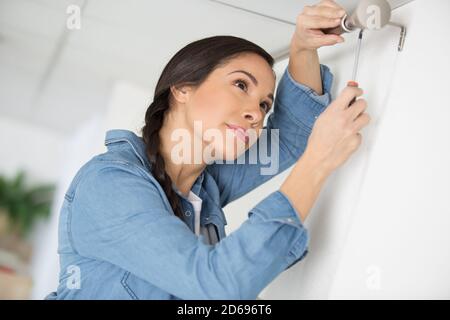 woman installing blinds with screwdriver Stock Photo