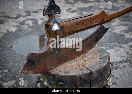 Old vintage axe on a wooden block ready to cut head. Stock Photo