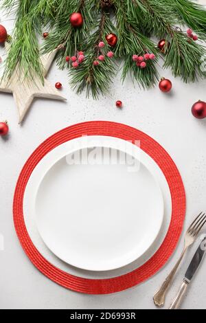 Christmas table setting with white and red elegant decorations on white table. View from above. Vertical format. Stock Photo