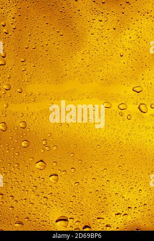 Close up view of cold drops on the glass of beer background. Texture of cooling alcohol drink with macro bubbles on the glass wall. Fizzing or floating up to top of surface. Golden colored. Stock Photo