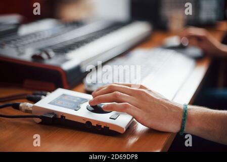 Close up vew of hand on interface. Sound engineer working and mixing music indoors in the studio Stock Photo