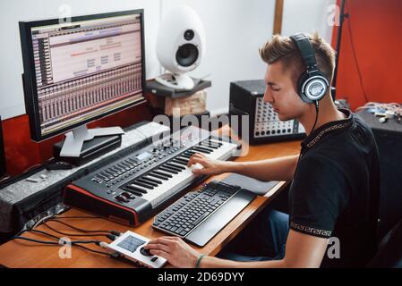 Sound engineer in headphones working and mixing music indoors in the studio Stock Photo