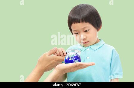 A boy looking through magnifying glass to the Earth on hands,  Teach Kids about the World Concept, Elements of this image furnished by NASA
